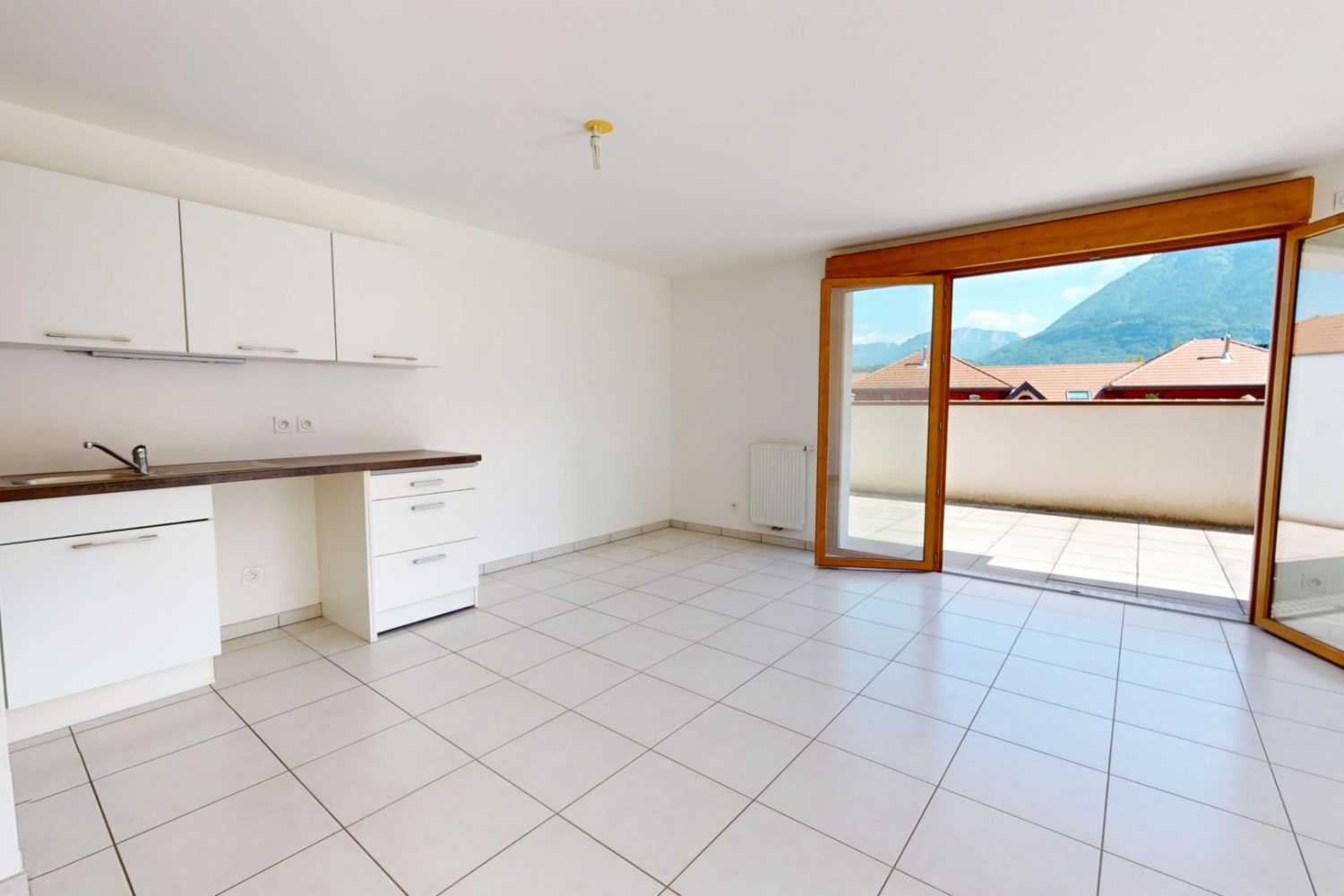 Salon séjour lumineux avec accès terrasse dans un appartement T3 à vendre à Duingt proche du lac d’Annecy