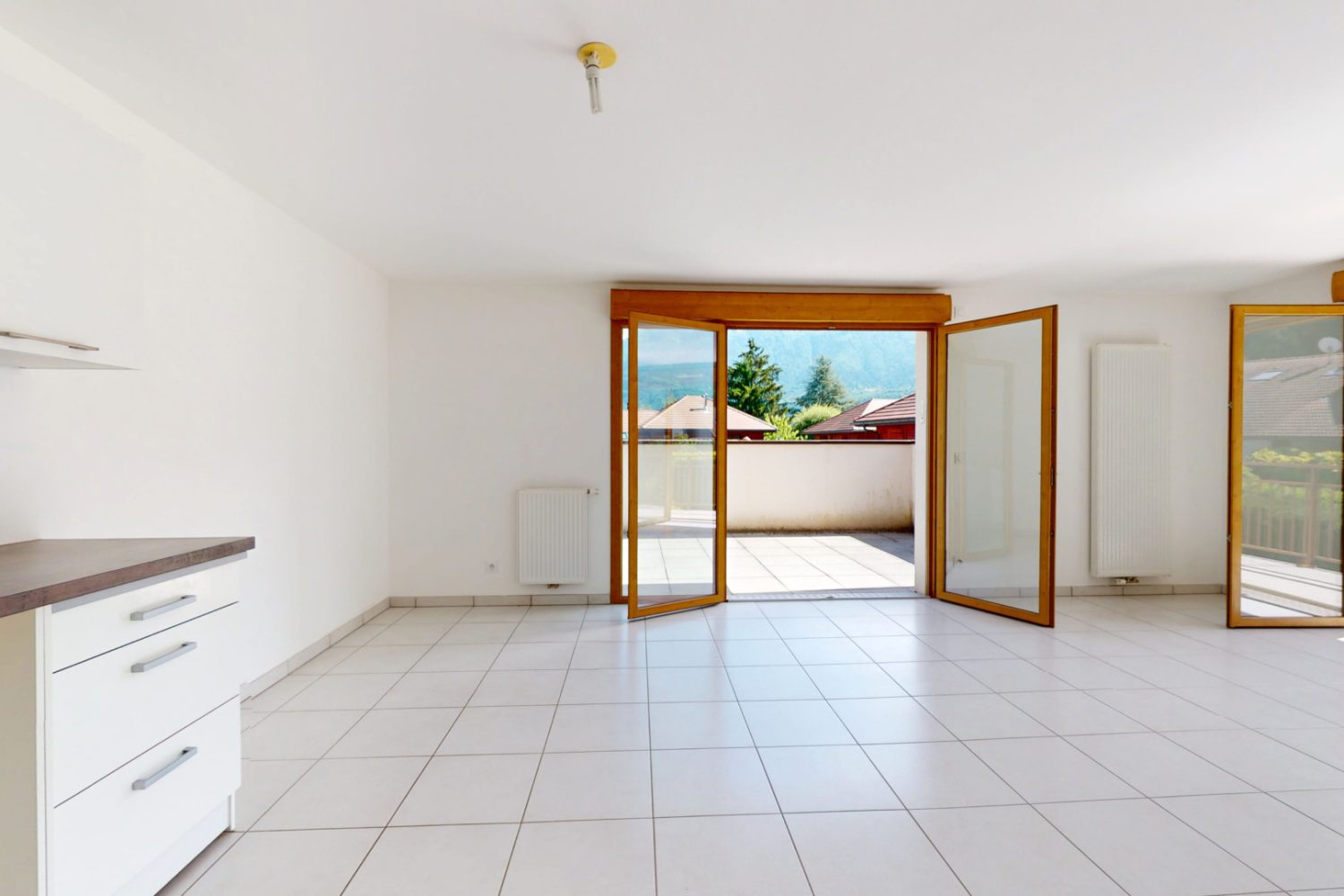 Salon séjour lumineux avec accès terrasse dans un appartement T3 à vendre à Duingt proche du lac d’Annecy