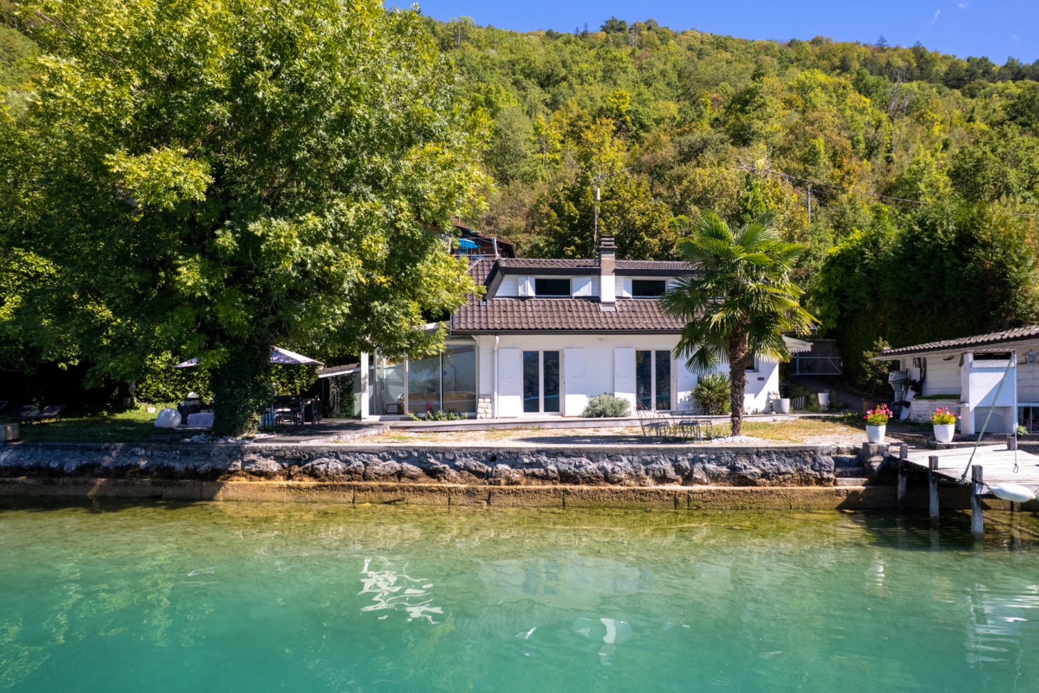 Ponton privé d'une maison pieds dans l'eau à Talloires-Montmin, avec vue sur le lac d'Annecy et les montagnes.