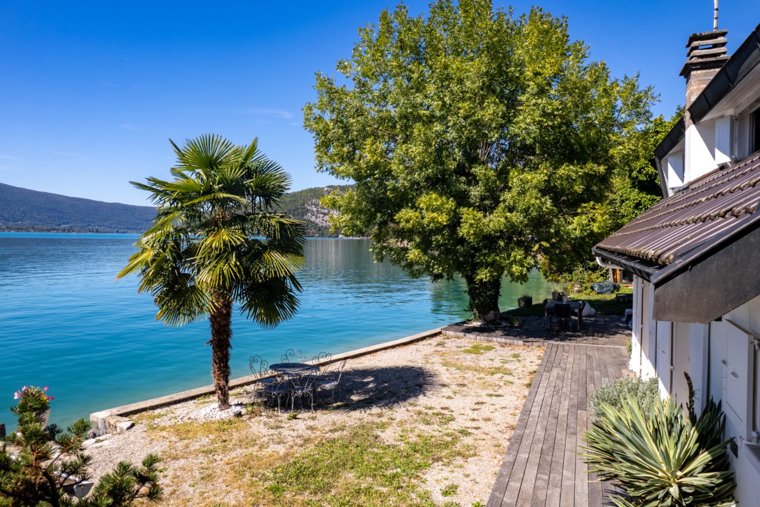 Ponton privé d'une maison pieds dans l'eau à Talloires-Montmin, avec vue sur le lac d'Annecy et les montagnes.