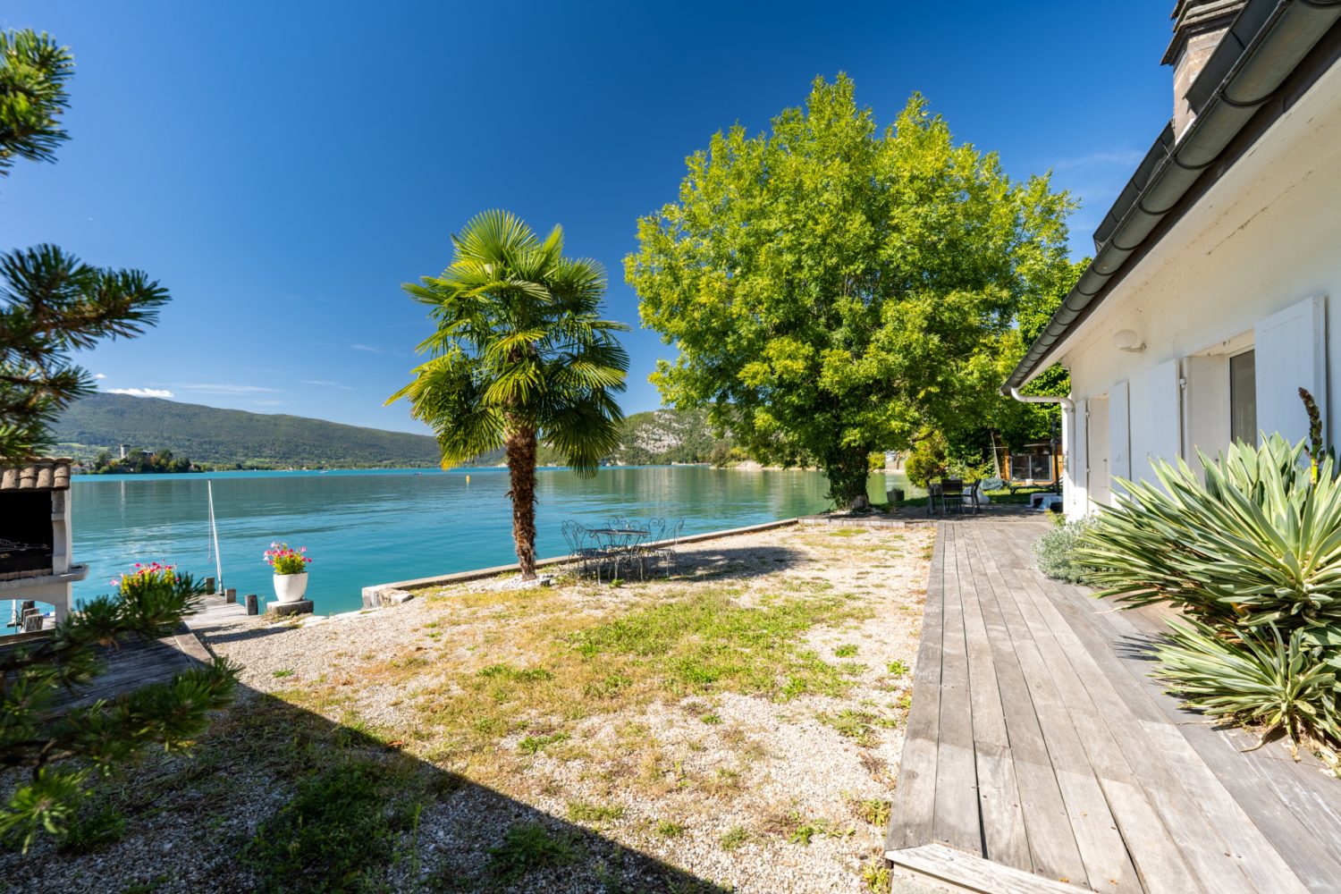Ponton privé d'une maison pieds dans l'eau à Talloires-Montmin, avec vue sur le lac d'Annecy et les montagnes.